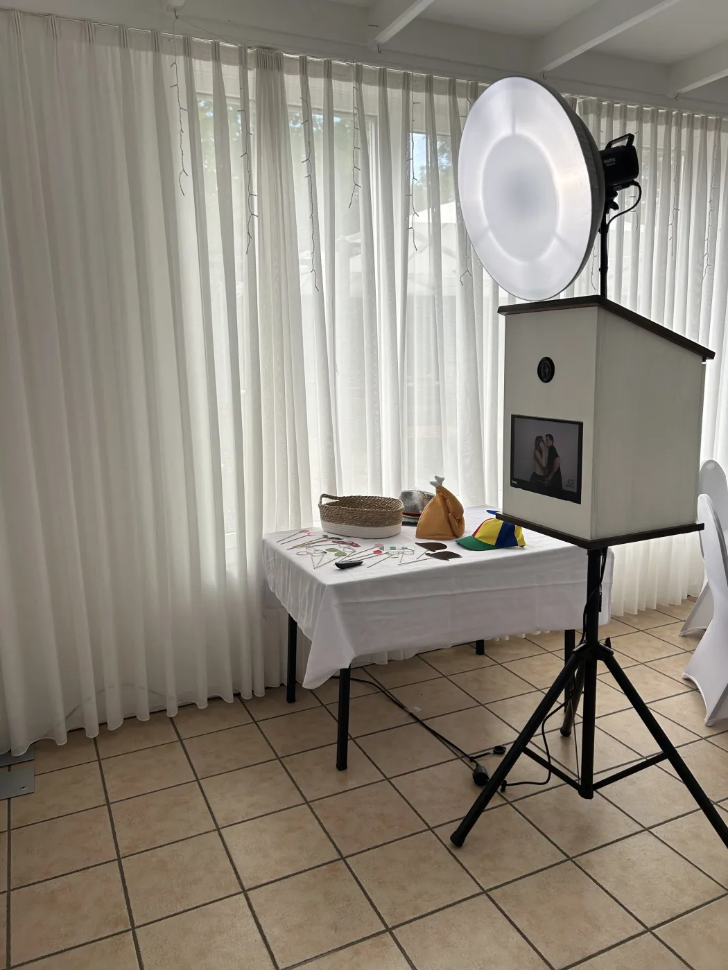 Requisiten-Tisch mit Hüten, Brillen und Schildern neben der aufgebauten Fotobox